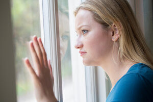 Sad woman looking out window wondering what is detox and how do I do it